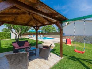 a patio with chairs and a swing and a pool at Holiday Home Nikolina - Roj412 by Interhome in Sveti Petar u Šumi