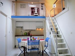 a small kitchen with a table and blue chairs at Holiday Home Les maisons de la forêt by Interhome in Lacanau-Océan +31 photos