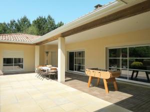 a house with a ping pong table on a patio at Holiday Home Eugénie - GHP190 by Interhome in Grayan-et-lʼHôpital