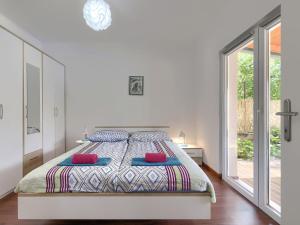 Un dormitorio blanco con una cama grande con almohadas rojas. en Holiday Home Vrt by Interhome, en Sveti Petar u Šumi