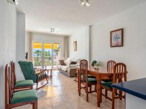 Apartment Sierra Mar by Interhome في Los Amarguillos: غرفة طعام وغرفة معيشة مع طاولة وكراسي