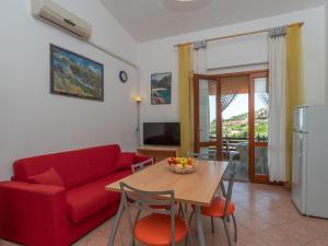 sala de estar con sofá rojo y mesa en Villa Gatti by Interhome, en Costa Paradiso