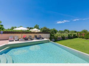 a swimming pool with chairs and umbrellas in a yard at Holiday Home Andrea - PUL463 by Interhome in Šišan
