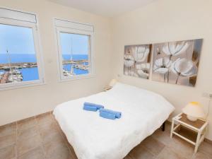 カラファットにあるApartment Marina del Port by Interhomeのベッドルーム1室(ベッド1台、窓2つ付)