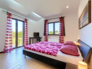 a bedroom with a bed with purple sheets and windows at Holiday Home Andrea - PUL463 by Interhome in Šišan