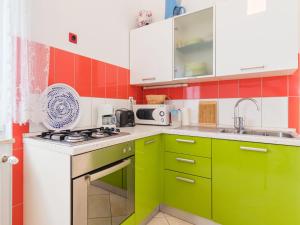 a kitchen with green cabinets and a stove top oven at Apartment Villa Sandra - PUL411 by Interhome in Vodnjan