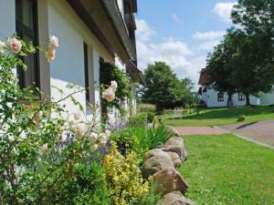 a garden of flowers in front of a house at Apartment Gästehaus Alte Schule-2 by Interhome in Dargun