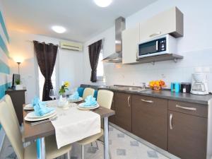 a kitchen and dining room with a table and chairs at Apartment Aquanur-2 by Interhome in Sovlje