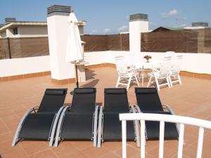 a patio with chairs and a table and a white umbrella at Apartment Nou Salou in Salou
