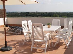 a group of white chairs and a table with an umbrella at Apartment Nou Salou in Salou