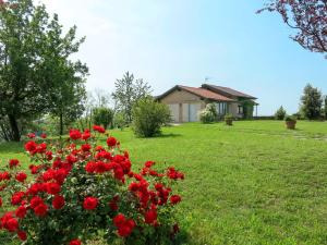 a field of red flowers in front of a house at Holiday Home Le Rose Rosse by Interhome in Grazzano Badoglio