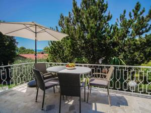 a patio with a table and chairs and an umbrella at Holiday Home Vesna by Interhome in Njivice