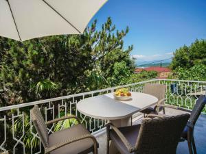 a table and chairs on a balcony with an umbrella at Holiday Home Vesna by Interhome in Njivice