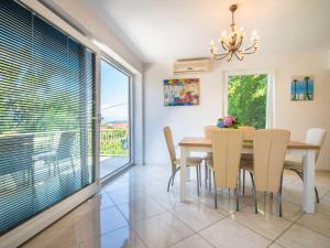 a dining room with a table and chairs and a large window at Holiday Home Vesna by Interhome in Njivice +25 photos