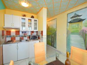 a kitchen with white cabinets and a painting on the wall at Apartment Ivana-2 by Interhome in Raslina