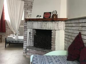 a living room with a brick fireplace and a bed at Lake It Easy Mandello in Mandello del Lario