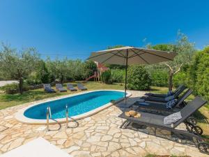 - une piscine avec un parasol, des chaises longues, une table et un parasol dans l'établissement Holiday Home Gea - RCA200 by Interhome, à Krnica