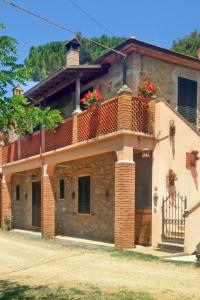 una casa antigua con flores en el balcón en Apartment Podere la Quercia by Interhome, en Riparbella