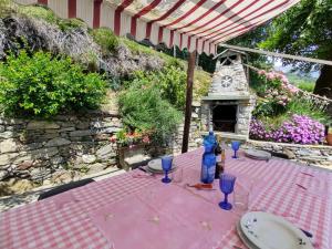 a pink table with plates and blue glasses on it at Holiday Home Baita dei Nonni-3 by Interhome in Livo