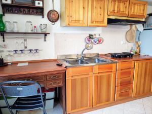 a kitchen with wooden cabinets and a sink at Apartment Baita dei Nonni-2 by Interhome in Livo +23 photos