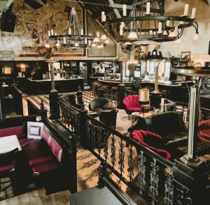 un restaurante con sillas rojas y un bar en Riffelhof, en Burgrieden
