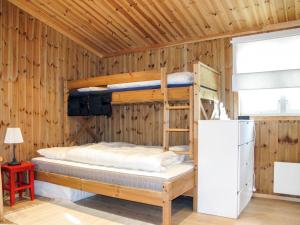 Chalet Skeisvegen - OPP208 by Interhome في Svingvoll: غرفة نوم بسريرين بطابقين في جدار خشبي