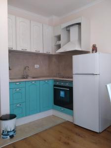 a kitchen with blue cabinets and a white refrigerator at Villa Gracia in Ravda