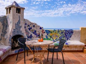 patio ze stołem i krzesłami oraz mozaikową ścianą w obiekcie Holiday Home Igor by Interhome w mieście Balcon del Mar