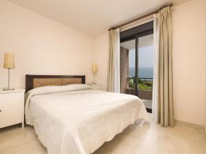 トロクス・コスタにあるApartment Amazing 3 bedrooms front sea view- by Interhomeの白いベッドルーム(ベッド1台、大きな窓付)