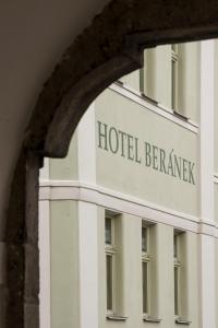 ein Schild für das Hotel Berwick durch ein Gebäude gesehen in der Unterkunft Hotel Beránek in Blatná
