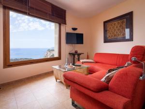 salon z czerwoną kanapą i oknem w obiekcie Holiday Home Igor by Interhome w mieście Balcon del Mar