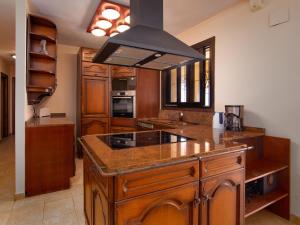 kuchnia z drewnianymi szafkami i kuchenką z piekarnikiem w obiekcie Holiday Home Igor by Interhome w mieście Balcon del Mar