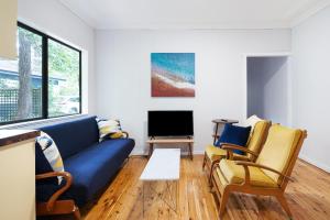 珀尔比奇Beach Shack semi detached, 2 Min Walk to Beach-Lilly Pilly的客厅配有蓝色的沙发和两把椅子