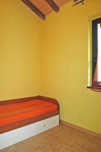Holiday Home Ulivetto by Interhome في مونتيفياسكون: غرفة بسرير في جدار اصفر