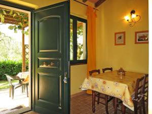 Holiday Home Ulivetto by Interhome في مونتيفياسكون: غرفة طعام مع طاولة وباب أخضر