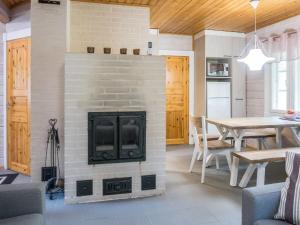 un camino in un soggiorno con tavolo e sedie di Holiday Home Sini 2b by Interhome a Lahdenperä