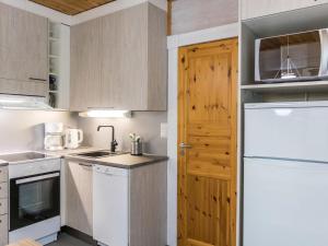 LahdenperäにあるHoliday Home Sini 2b by Interhomeの白い家電製品と木製のドアが備わるキッチン