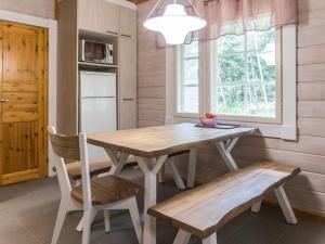 una cucina con un tavolo e una panca in legno e una finestra di Holiday Home Sini 2b by Interhome a Lahdenperä