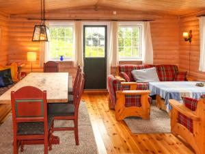 a living room with a bed and a table at Chalet Liaråket - OPP209 by Interhome in Svingvoll