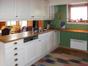a kitchen with white cabinets and a sink at Chalet Liaråket - OPP209 by Interhome in Svingvoll