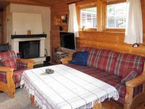 a living room with a couch and a tv at Chalet Liaråket - OPP209 by Interhome in Svingvoll