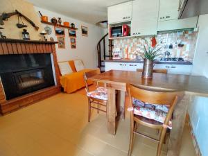 cocina con mesa, sillas y chimenea en Holiday Home Giulia by Interhome, en Dosso del Liro