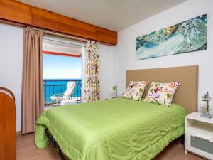 una camera con letto verde e vista sull'oceano di Apartment Apartamento Las Coronas by Interhome a Torremolinos