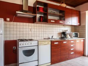 eine Küche mit weißen Geräten und braunen Schränken in der Unterkunft Apartment Regina - ICS103 by Interhome in Porozina