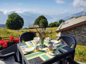 stół z talerzami, kubkami i kwiatami w obiekcie Holiday Home Il Nido d'Aquila - GRV635 by Interhome w mieście Livo