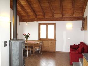 salon ze stołem i czerwoną kanapą w obiekcie Holiday Home Il Nido d'Aquila - GRV635 by Interhome w mieście Livo