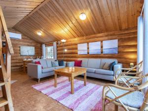 a living room with a couch and a table at Holiday Home Kalliomökki by Interhome in Huuhanaho