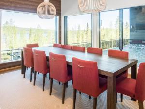 ein Esszimmer mit einem Tisch und roten Stühlen in der Unterkunft Holiday Home Holy lake chalet b by Interhome in Niskala