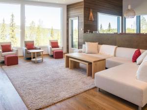 ein Wohnzimmer mit Sofas, Tischen und Fenstern in der Unterkunft Holiday Home Holy lake chalet b by Interhome in Niskala