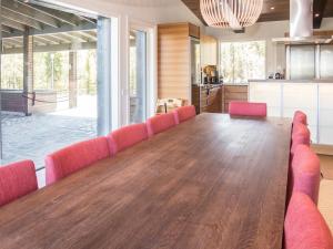 ein großes Esszimmer mit einem langen Tisch und roten Stühlen in der Unterkunft Holiday Home Holy lake chalet b by Interhome in Niskala + 34 Fotos